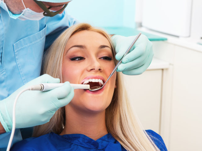 Dentist examines teeth of the blonde girl patient with teeth-camera